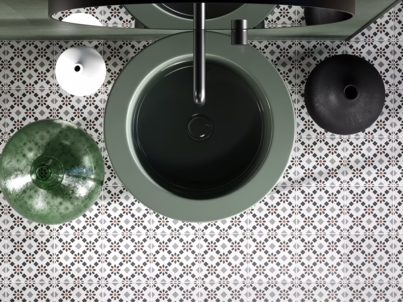 Suelo de baño contemporáneo con azulejos decorativos en balnco, gris, nego y detalles en rojo teja, lavabo verde oscuro en vista cenital