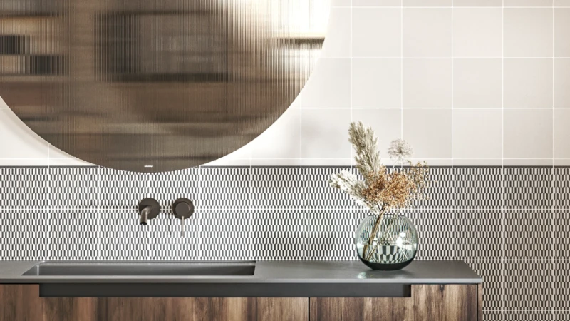 Pared del cuarto de baño hecha con azulejos blancos y decorados