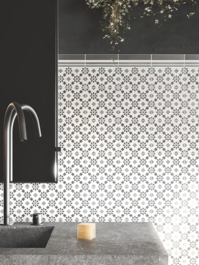 Pared de baño hecha con baldosas decoradas en colores blanco, gris y turquesa