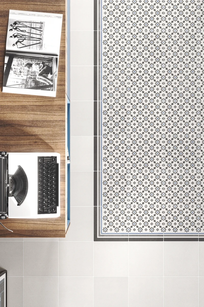 Pavimento decorado con base de cemento blanco y diseño en gris, negro y azul